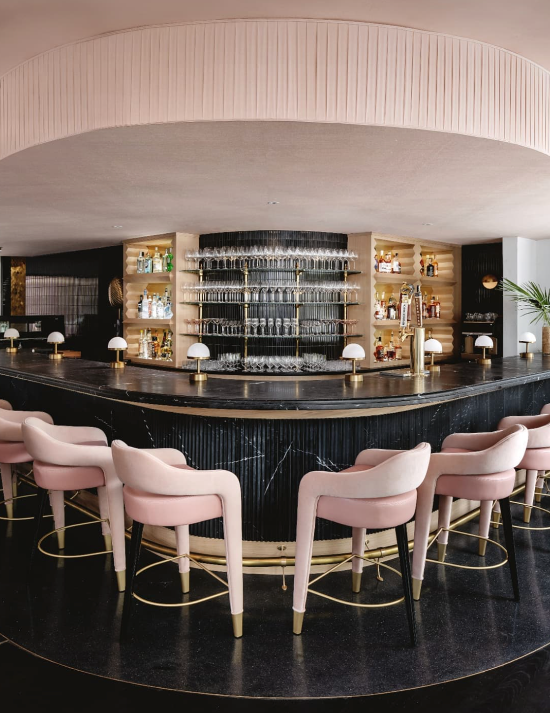 Cordless art deco lamps restaurant installation at a stylish bar with modern decor and pink upholstered chairs.