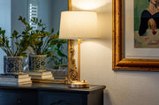 OPEN BOX Alexis Cordless Table Lamp in antique brass with linen shade on a console table.