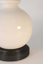off white ceramic body of a cordless lamp on a black metal battery base
