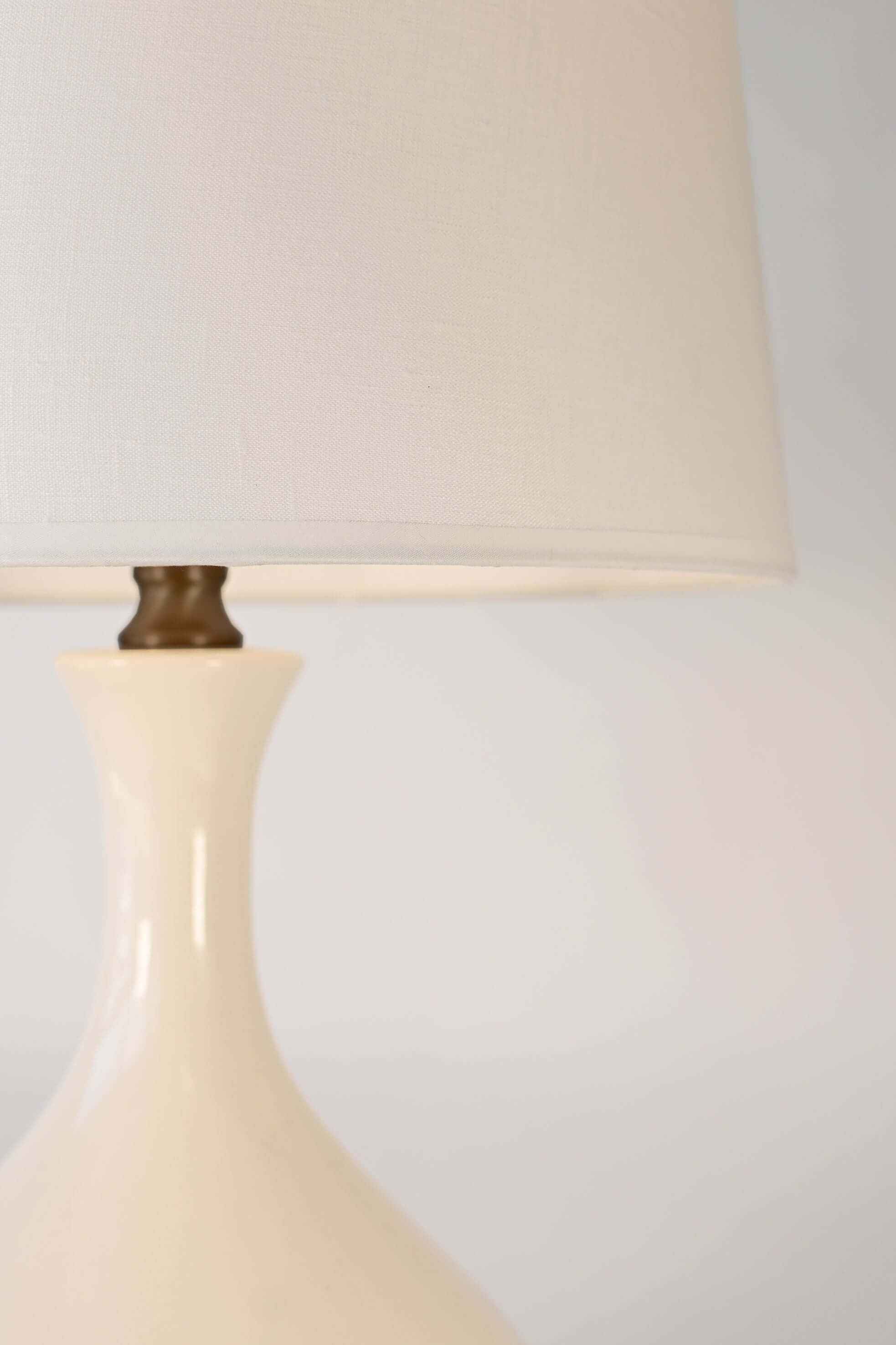 Close-up of a ivory ceramic lamp with a off white shadebackground