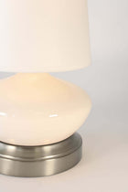 Close-up of a ivory ceramic table lamp with an off white shade battery operated