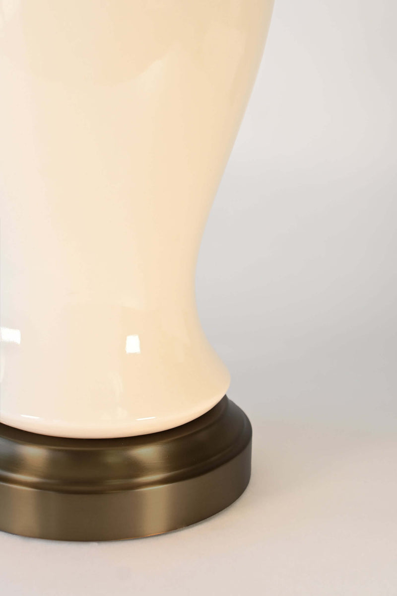 Close-up of a cordless ceramic lamp with an off white shade and bronze black base 