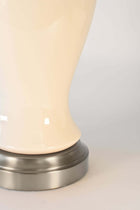 Close-up of a lamp with ivory ceramic body and metallic base made in America