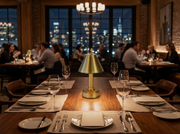 warmly lit restaurant in city featuring cordless mini brass lamps from modern lantern
