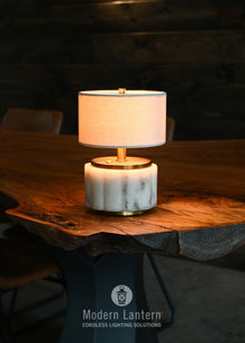Table lamp with marble base on a wooden table, brand 'Modern Lantern'