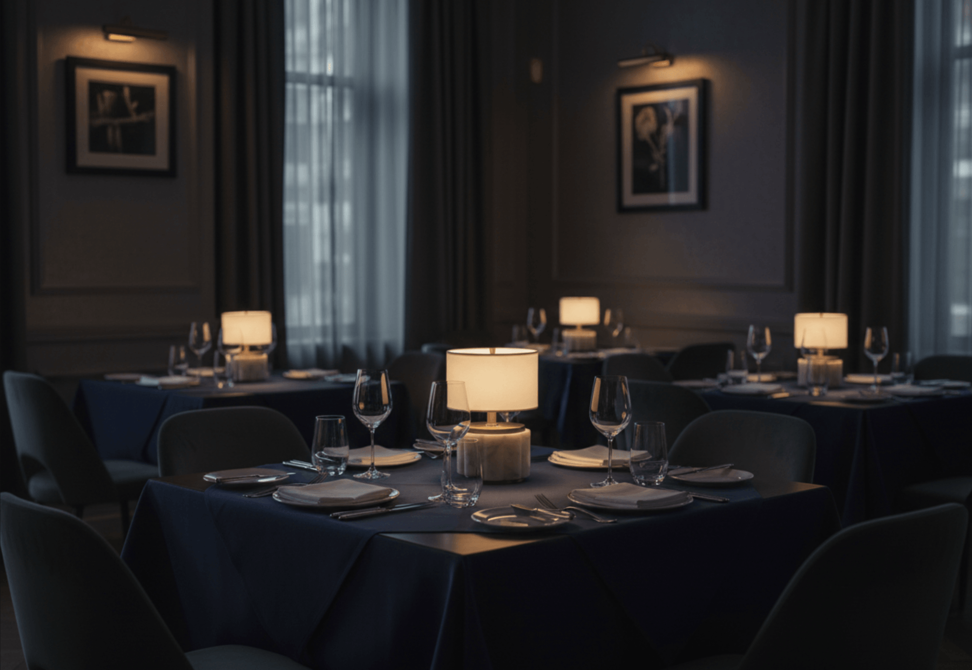 Dining room with tables set for dinner, dimly lit with modern lantern Nora cordless lamps