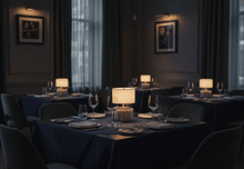 Dining room with tables set for dinner, dimly lit with modern lantern Nora cordless lamps