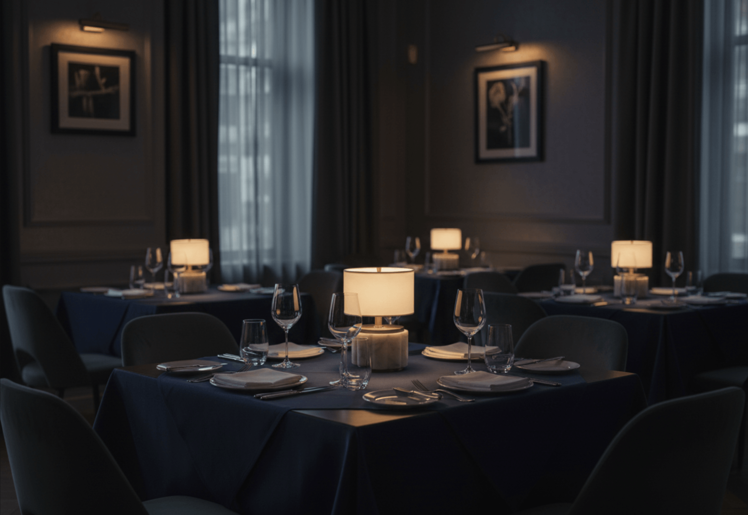 Dining room with tables set for dinner, dimly lit with modern lantern Nora cordless lamps