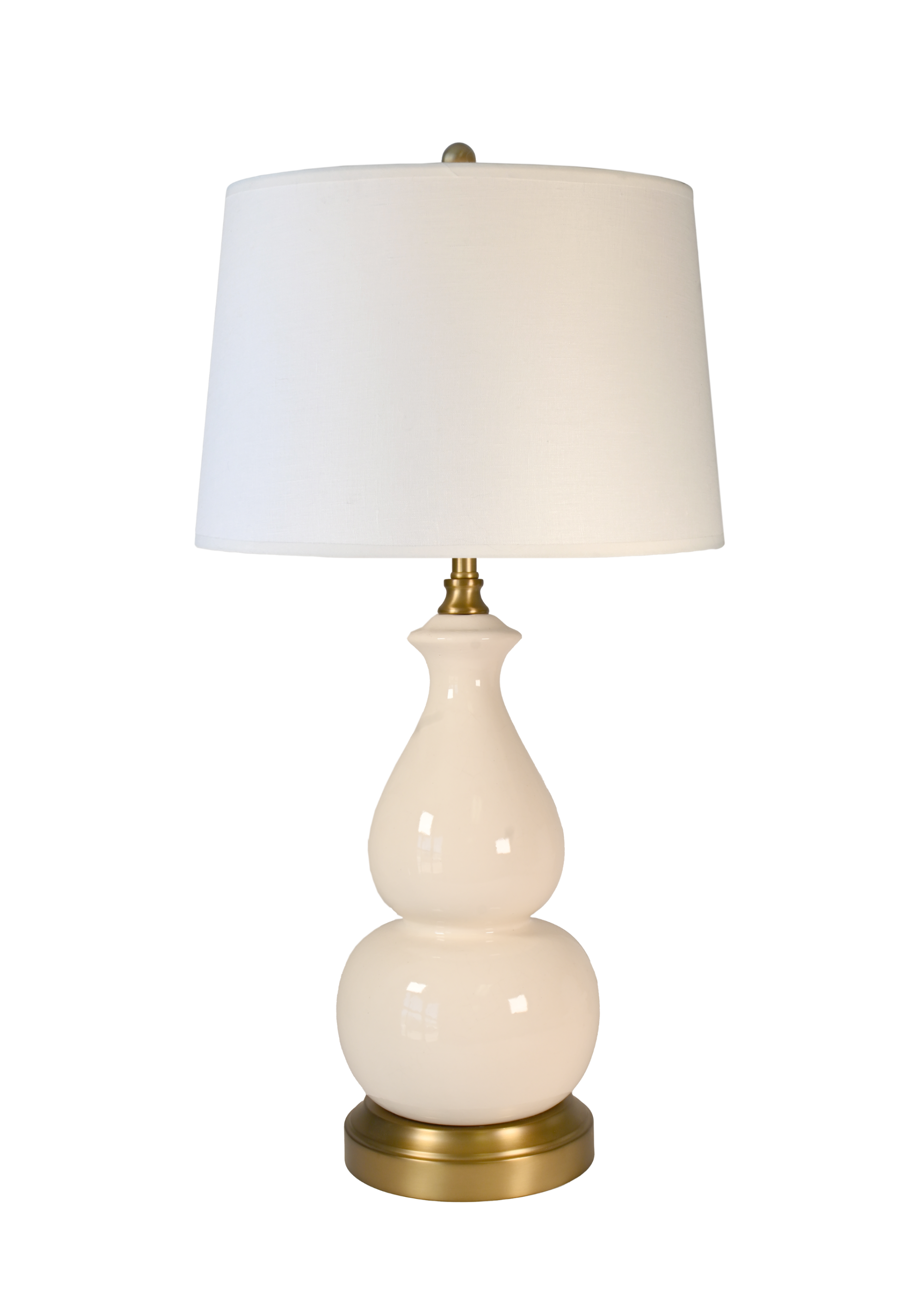 A cordless table lamp with an off white drum shade, a glossy cream gourd-shaped ceramic base, and a brass-finished neck and base, shown against a plain white background.