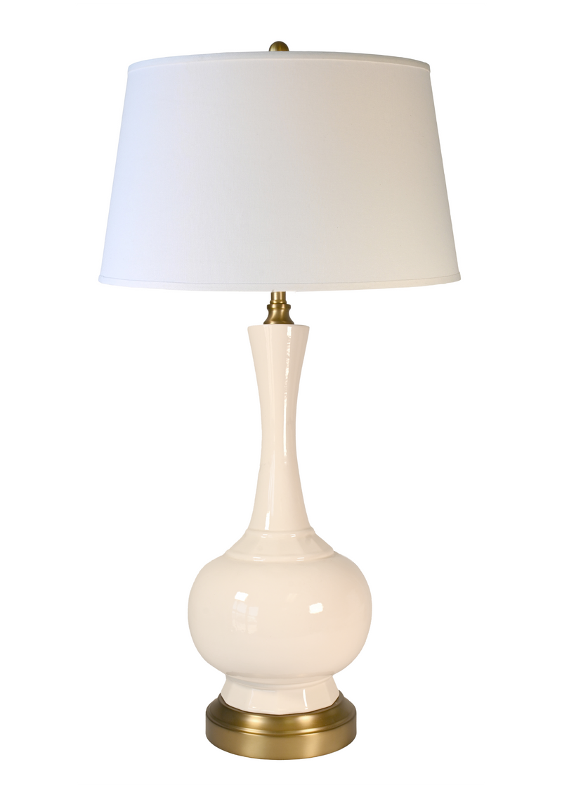 A cordless table lamp with a glossy cream ceramic base, an off white fabric linen shade, and brass-finished metal accents at the neck and base.
