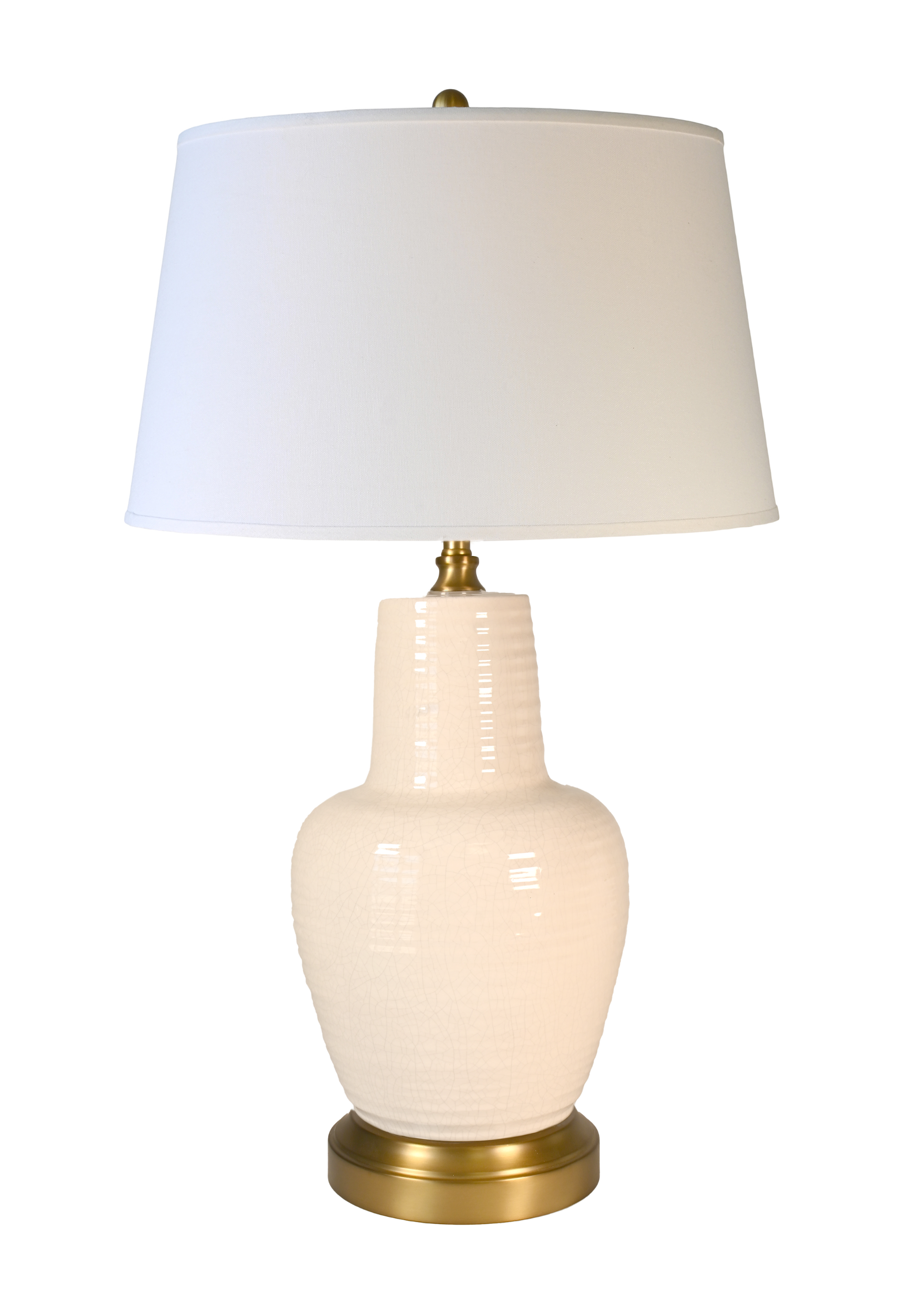 A cordless table lamp with an ivory ceramic ribbed vase base, an off white fabric drum shade, and a brass-finished metal neck and circular base.