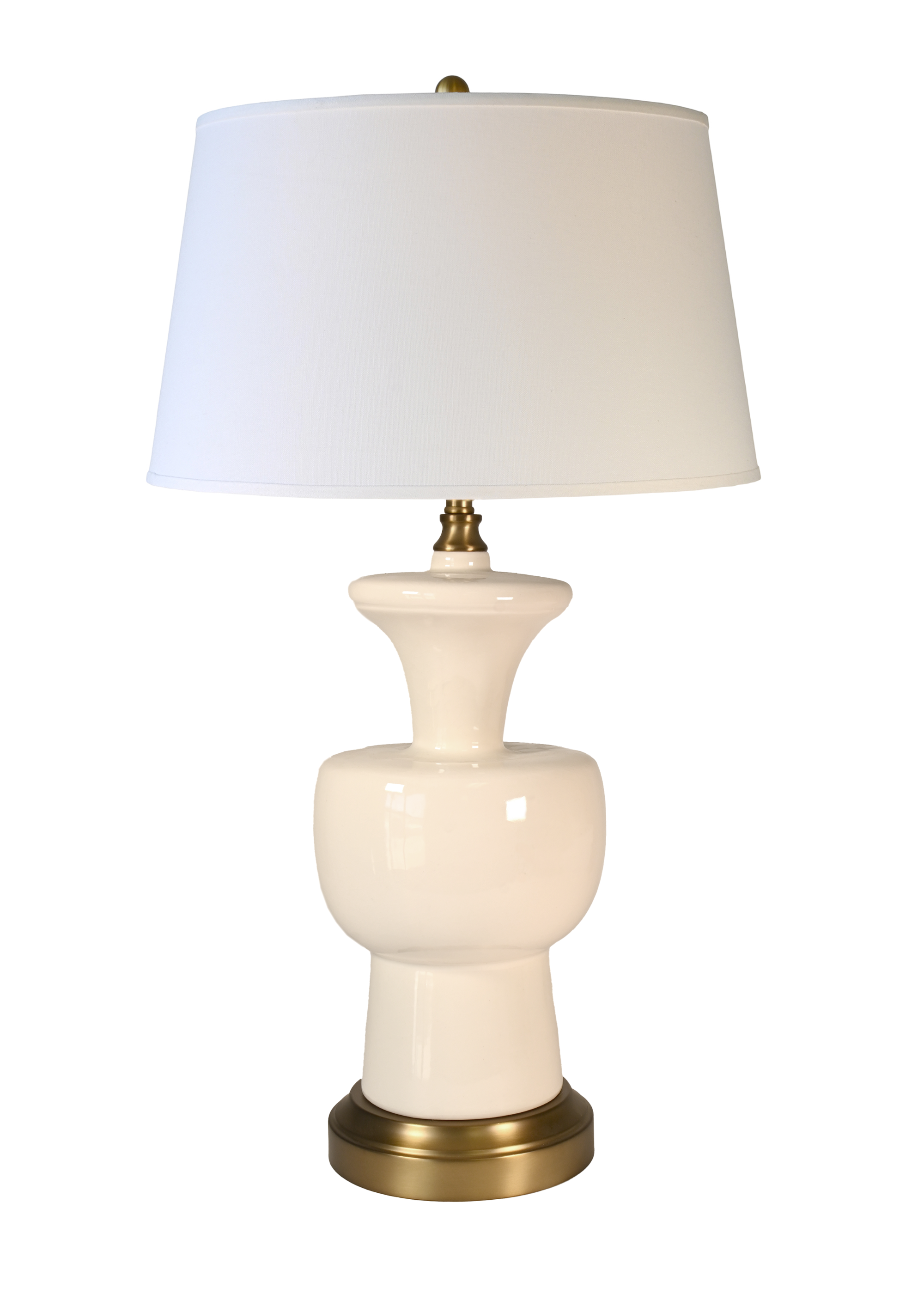 A cordless table lamp with a glossy cream ceramic vase-shaped base, an off-white fabric drum shade, and a polished brass-finished metal top and bottom trim