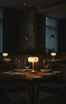 Dining table fine restaurant with wine glasses and a cordless minilamp in a dimly lit room
