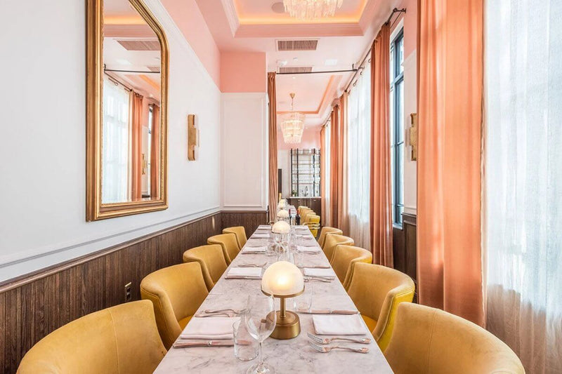 Mini cordless lamp on a stylish dining table in a restaurant setting with elegant decor and warm lighting.